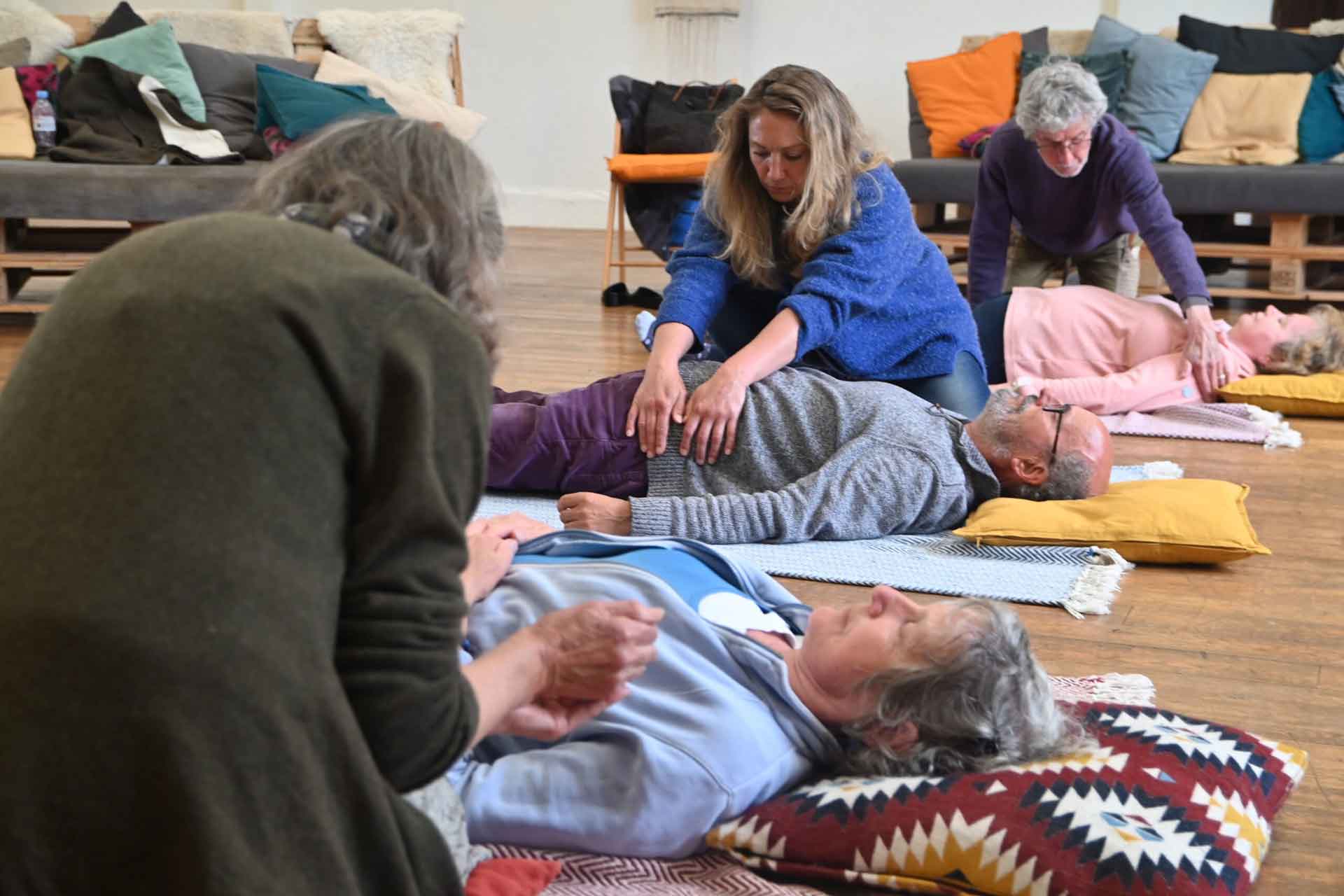 people lying on floor with a partner gently moving their body