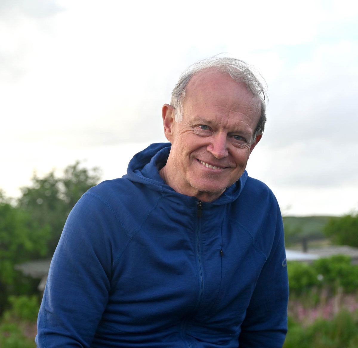 Philip Shepherd, creator and co-director of the Embodied Present Process, wearing a blue jacket outdoors with greenery in the background